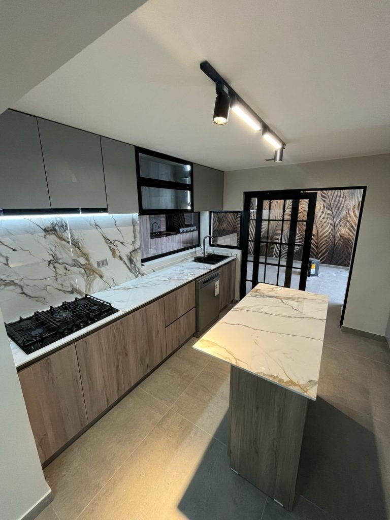 Cocina con isla en cuarzo y nogal — mueble de Innova RS