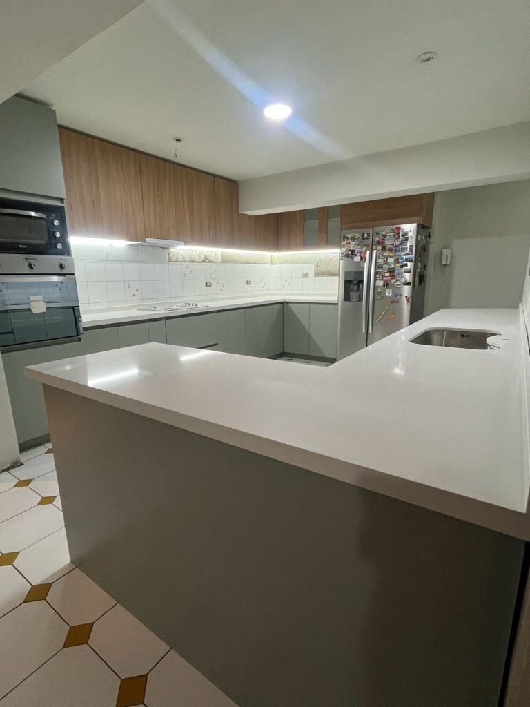 Cocina en U con isla y cubierta blanca — mueble de Innova RS